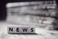 Black and white image of the word NEWS in wooden blocks.