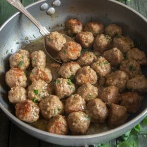 A pan of cooked meatballs with parsley.